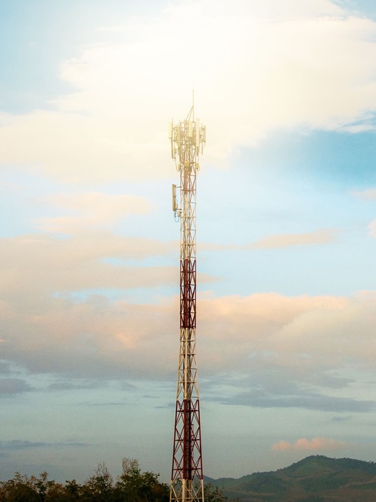 Antenna tower with sunset sky.